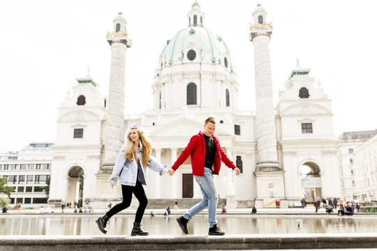 Young couple walking holding hands around Vienna