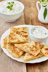 Pita bread with cheese and matsun sauce on a white plate