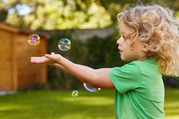 Boy catching soap bubbles