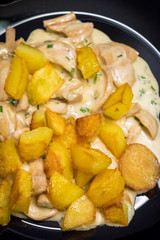 Mushroom sauce and potatoes on black plate