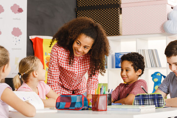 Smiling teacher explaining lesson © Photographee.eu