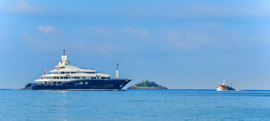 Fototapeta na wymiar Luxusyacht und Fischerboot treffen sich im Meer