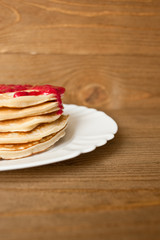 Pancake with berry jam.  Wooden background.