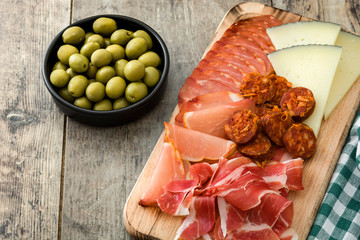 Spanish cold cuts (embutidos). Cheese, sausage and ham on wooden table

