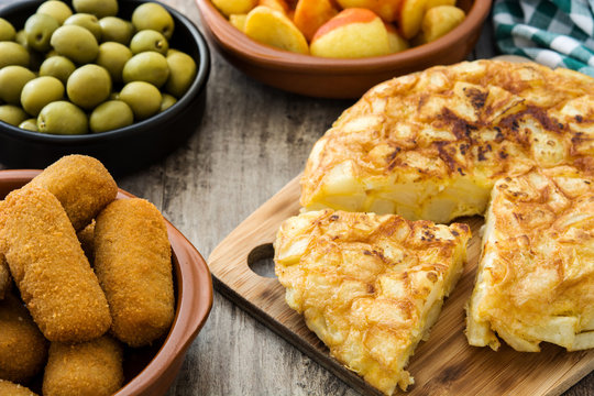 Traditional spanish tapas. Croquettes, olives, omelette, ham and patatas bravas on wooden table

