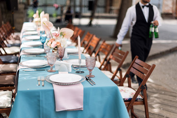 Flower table decorations for holidays and wedding dinner. Table set for holiday, event, party or wedding reception in outdoor restaurant.