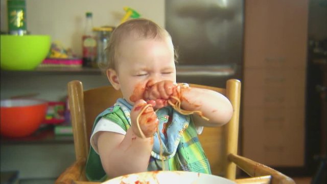 Funny child playing with spaghetti and sauce. Scene 6