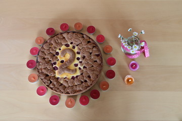 Kuchen dekoriert mit Zahl 2 und Kerzen sowie Gänseblümchen
