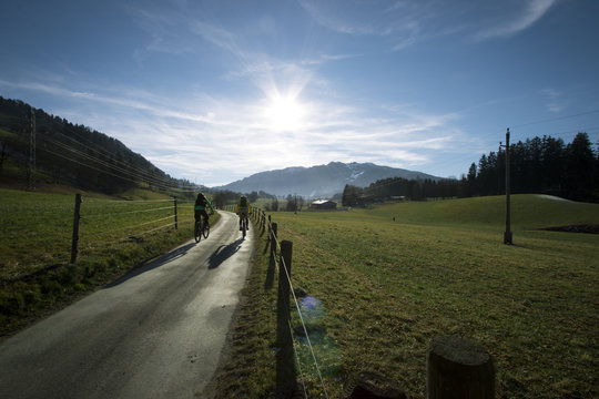Velofahrer / Biker auf Weg in den Alpen im Sonnenschein