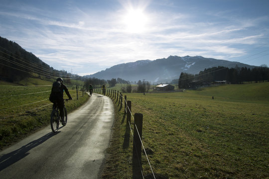 Velofahrer / Biker auf Weg in den Alpen im Sonnenschein