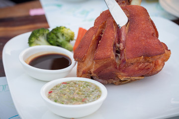 German BBQ pork knuckle served with  thai spicy sauce. Pork hock with sauerkraut