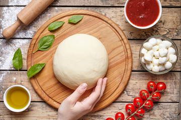 Pizza cooking ingredients. mozzarella, tomatoes, basil, olive oil, spices. Work with the dough. Top view. Flat lay.