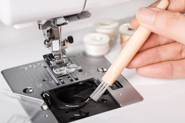 clean the sewing machine with a brush