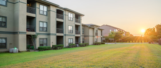 View from grassy backyard of a typical apartment complex building in suburban area at Humble,...