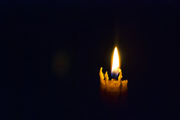 The candle burns in the dark
