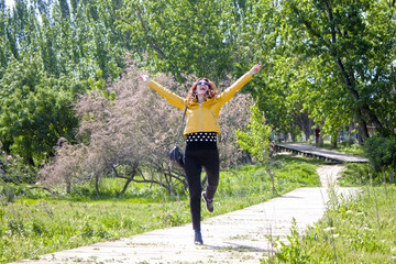 Fototapeta na wymiar happy woman hopping in the park celebrating her happiness