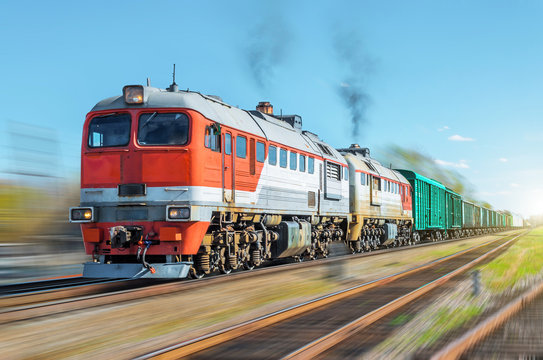 Fototapeta Freight train blur motion railroad embankment rail.