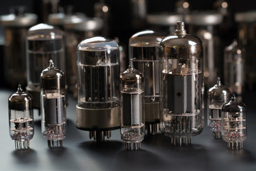 Radio tubes of different shapes and sizes on a gray background