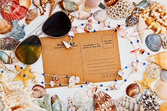 Mediterranean styled still life with vintage postcard, sunglasses and sea shells