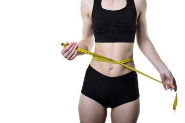 Young woman measuring waist with measuring tape, isolated on white background.