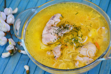 Soup with chicken meat on a blue background