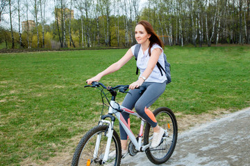 Portrait of happy young bicyclist riding in park