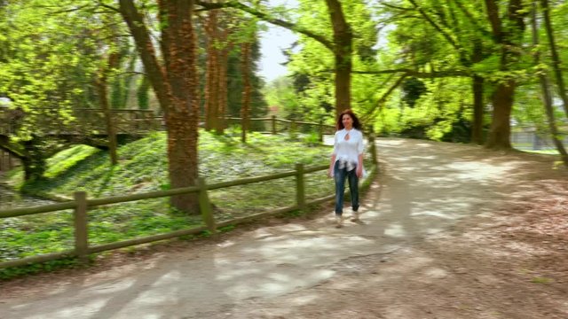 timelapse of woman walking in a park near river