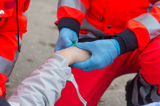 Rettungssanit&auml;ter legt einen Zugang und gibt Medikemante