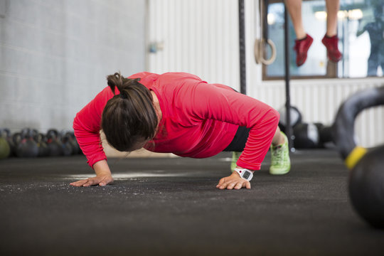 Fit Female Athlete Doing Pushups In Health Club