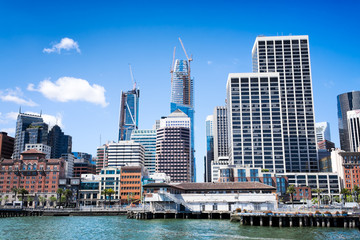 Obraz premium San Francisco waterfront and skyline viewed from the bay. Crisp image of buildings old and new including skyscrapers under construction.