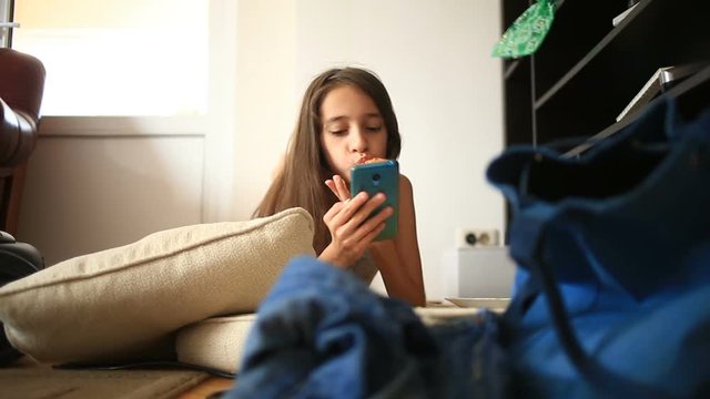 A little girl is shirking her homework, playing on her mobile phone. Cleaning of the children's room. Disorder in the teen room