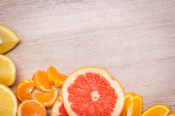 lemon, orange, kiwi, grapefruit, mandarin on a wooden surface. arrangement of sliced fruit. Top view with copy space for text