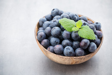 Fresh blueberries natural coconut in a bowl on a gray background.