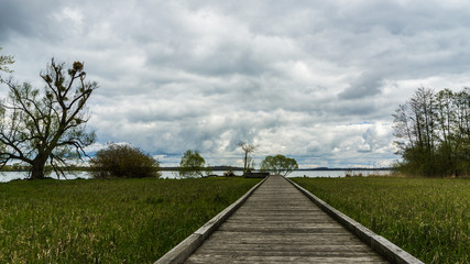 Fototapeta na wymiar wooden footpath to the lake