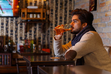Young man sitting in a cafe and working on his laptop.