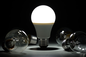 Glowing led lamp and incandescent bulbs in the dark