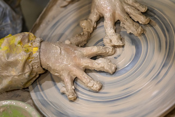 Hands of young girl in clay on pottery wheel