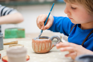 small boys make a product made of ceramics