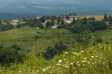 Scene with mountain glade, forest and residential district of bulgarian village Plana, Plana 

mountain, Bulgaria 