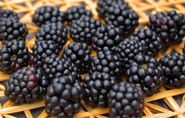 Fresh blackberries on a background of a straw mat.