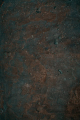 Cracked old stone wall background, dark grunge texture close up.