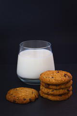 cookies and a glass of milk on black background 