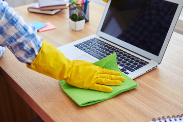 Female in yellow rubber gloves cleaning with mop laptop