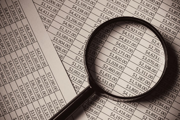 Magnifying glass on documents. Money chart dollars report.