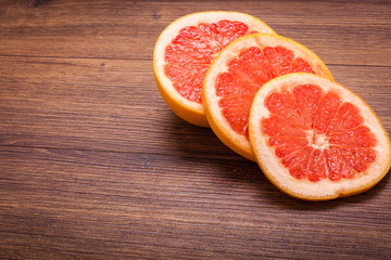 orange grapefruit on a wooden surface. arrangement of sliced fruit.
