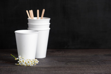 Styrfoam cups, wooden sticks and flower on the darl brown tableflower