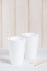 Two empty styrofoam cups with wooden sticks
