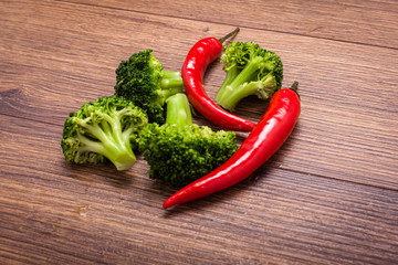 green broccoli, red chili on a wooden surface