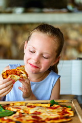 Little girl eating pizza