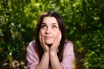 Portrait of dreamy young woman with hands over face